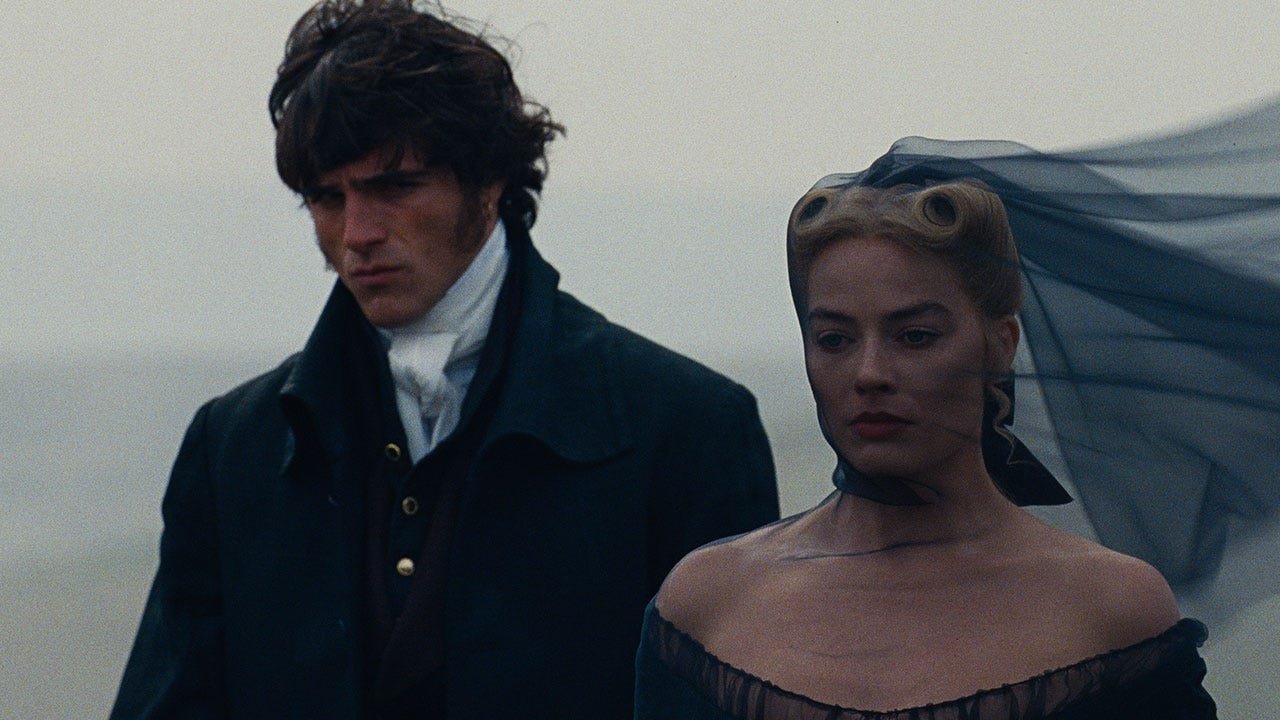 Margot Robbie as Catherine and Jacob Elordi as Heathcliff standing on the misty Yorkshire Moors in Emerald Fennell’s Wuthering Heights adaptation.