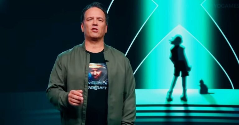 Phil Spencer and Asha Sharma standing before an Xbox logo during a Microsoft corporate transition event in Redmond.